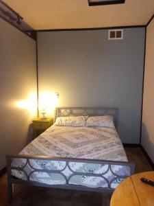 1 dormitorio con 1 cama y 1 mesa con lámpara en Bigfoot RV & Cabins Park, en Happy Camp