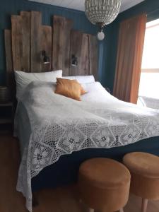 a bedroom with a bed and two stools at Stryn Sentrum 3 soverom in Stryn