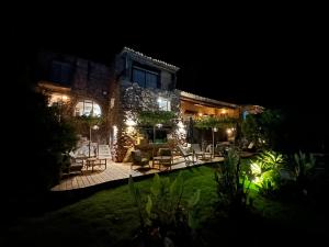 a house with a yard at night with lights at Hôtel Ambassador Palombaggia in Porto-Vecchio