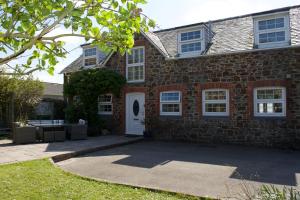 a brick house with a white door at Coach House. Falcon Mews in Bude