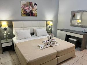 ein Schlafzimmer mit einem Bett mit zwei Teddybären darauf in der Unterkunft Maria Hotel Sisi in Sisi