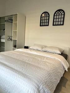 1 dormitorio con cama blanca y espejo en Appartement Duplex avec jardin, en Ingersheim