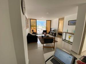 sala de estar con ordenador portátil en la planta en Apartamento completo en exclusivo sector 401, en Ibagué