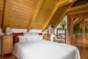 バラトンアルマーディにあるFüge házの白いベッドと木製の天井が備わるベッドルーム1室が備わります。