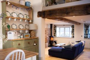a living room with a blue couch and a table at The Forge - Beautiful Contemporary Barn - Hot Tub in Bridgnorth