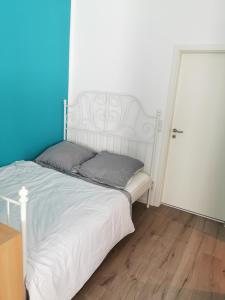 um quarto com uma cama branca e uma parede azul em Nr 3 Ferienwohnung am Teutoburger Wald 