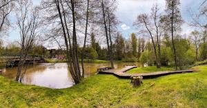 einen Park mit einer Brücke und einem Fluss mit Bänken in der Unterkunft Maison le Bonheur - 12P Met Zwembad FR Vakantiehuis in Magny-lès-Jussey