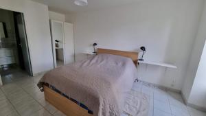 ein Schlafzimmer mit einem Bett in einem weißen Zimmer in der Unterkunft Logement Servon-sur-Vilaine in Servon-sur-Vilaine