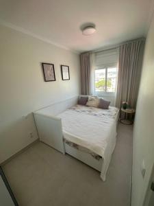 a small bed in a room with a window at Cunit, front line with sea view in Cunit