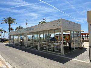 a restaurant with tables and chairs in a building at Cunit, front line with sea view in Cunit