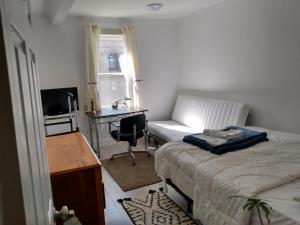 Schlafzimmer mit einem Bett, einem Schreibtisch und einem Schreibtisch in der Unterkunft Healing Touch Holistic Living Space in Amherst