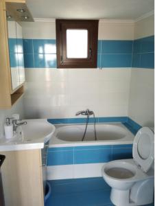 a bathroom with a tub and a toilet and a sink at Poli's Ideal Holiday Home - Fully renovated ! in Rakhónion