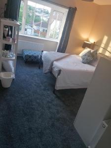a bedroom with two beds and a window at Dún Eoin Carrigaline in Carrigaline