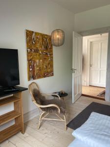 - une chambre avec une chaise, une télévision et un lit dans l'établissement Dobbelt værelse Carlsminde, à Stenstrup