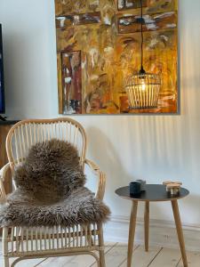 a chair with a furry cushion next to a table at Dobbelt værelse Carlsminde in Stenstrup