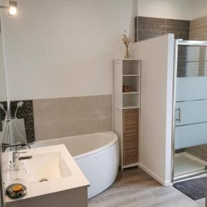 a bathroom with a white tub and a sink at Agréable maison de ville, de 1 à 6 personnes, à 5 min à pied du centre ville de Cognac in Cognac