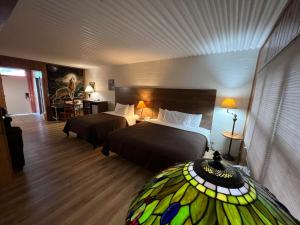 een slaapkamer met 2 bedden en een glas-in-loodraam bij Smoky Falls Lodge in Maggie Valley