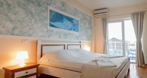 een slaapkamer met een bed en een groot raam bij Atena Hotel in Costinesti