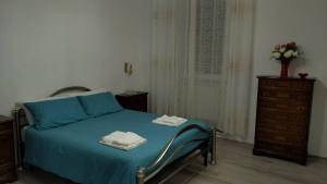 a bedroom with a blue bed and a dresser at Cozy Home Away from Home in Tarquinia