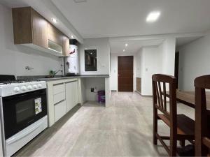 a kitchen with a stove and a dining room at Departamentos Agringof 2 in Balcarce