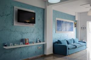 een woonkamer met een blauwe bank en een tv bij Atena Hotel in Costinesti