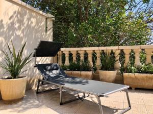 een stoel op een patio naast een hek bij Coté Jardin est un spacieux et lumineux T3, entièrement rénové, à 2 pas de l'Hérault et à 10min du bord de mer Proche du centre historique et du fabuleux château Laurens, vous apprécierez le calme de sa belle terrasse et la vue superbe sur le jardin in Agde