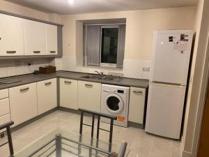 a kitchen with a white refrigerator and a washing machine at TenPickering Place in Manchester