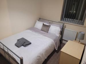 a bedroom with a bed with two towels on it at TenPickering Place in Manchester