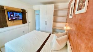 ein Schlafzimmer mit einem Bett und einem TV an der Wand in der Unterkunft Beira Mar 226 Praia - NBI - Ponta Negra Beach - Pe na areia e ultimo andar e Vista x Mar in Natal