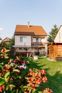 una casa con terraza y un patio con flores en Piknik Vendégház, en Bogács