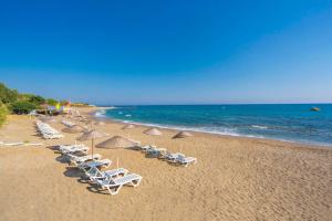 eine Reihe von Liegestühlen und Sonnenschirmen am Strand in der Unterkunft Club Sun Paradise Hotel in Alanya