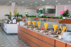 una línea de buffet en un restaurante con platos y comida en Club Sun Paradise Hotel en Alanya