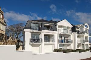 サンティレール・ド・リエにあるSt Gilles Appartement face merの黒屋根の白いアパートメントビル