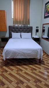 リマにあるAnciejo inn llのウッドフロアのベッドルーム(白い大型ベッド1台付)