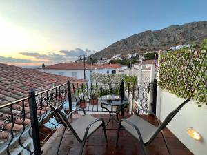 a balcony with chairs and a table on a balcony at Perakis Apartments in Hydra