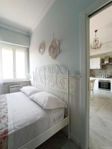 una camera con letto bianco e una cucina di Casa Vacanze Appartamento Bijoux a Civitanova Marche
