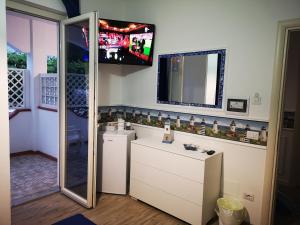 łazienka z telewizorem na ścianie i lustrem w obiekcie La Casa di Alfonso w mieście Marina di Camerota