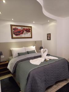 un cisne está sentado en la parte superior de una cama en Casarão da Ducha Hotel, en Campos do Jordão