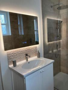a bathroom with a white sink and a shower at Garden Apartment, Central Harrogate with parking in Harrogate