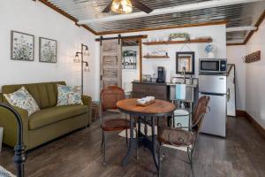 a living room with a couch and a table and a kitchen at NEW! Ladybug @ Firefly Grove w/ Blanco River Access in Wimberley