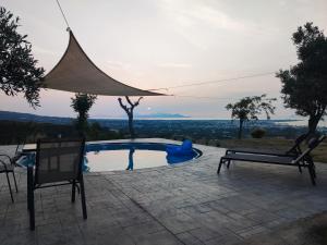 una piscina con tavolo e due sedie di Yiorgos, amazing sunset view house a Psalidi