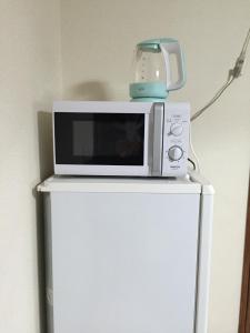 a microwave sitting on top of a refrigerator at Ogi - House - Vacation STAY 33925v in Saga