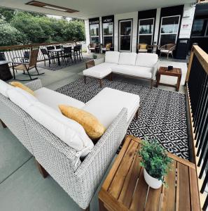un patio con tavolo e sedie in vimini bianche di Silver Sands Motel a Westport