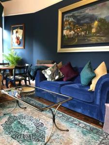 a living room with a blue couch and a table at The Huntress Suite in Buxton