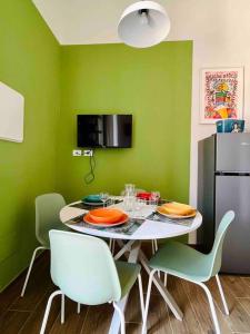 a dining room with a table with chairs and a refrigerator at Casa Bonita Bolognina in Bologna