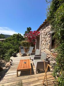 a wooden deck with chairs and a table at Hôtel Ambassador Palombaggia in Porto-Vecchio
