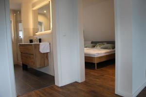 y baño con cama, lavabo y espejo. en Ferienwohnung Fritz, en Jork