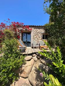 a patio with chairs and a house with flowers at Hôtel Ambassador Palombaggia in Porto-Vecchio