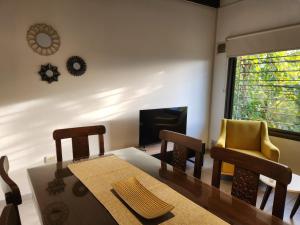 a dining room with a table and chairs and a television at Apartamento Deluxe Senderos del Vino II, desayuno Opcional in Mendoza