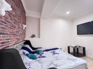 a bedroom with a bed and a brick wall at Soft Aparts in Chişinău